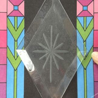 Diamond-shaped clear glass panel with a starburst engraving, set against a colorful stained-glass-inspired background.