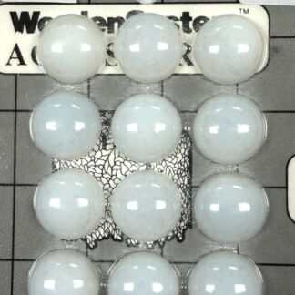 Top-down view of twelve white game stones arranged in a 3-by-4 rectangle on a gray grid mat with label text visible in the background.